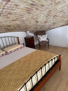 a bedroom with a bed and a brick wall at La casina di Soccorsa in Poggio Imperiale