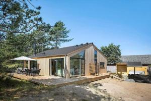 una casa in legno con terrazza e tavolo di 0235-Romo-Norre-Frankel-63 a Rømø Kirkeby