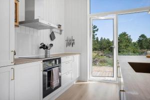 una cucina con mobili bianchi e una grande finestra di 0235-Romo-Norre-Frankel-63 a Rømø Kirkeby Altre 23 foto