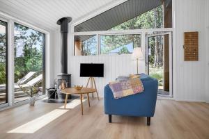 un soggiorno con una sedia blu e un tavolo di 0235-Romo-Norre-Frankel-63 a Rømø Kirkeby