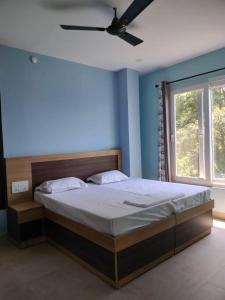 a bedroom with a large bed with a ceiling fan at Shivdham Homestay in Mandi
