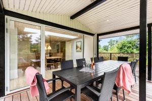 a dining room with a table and chairs on a deck at 8017-Knebel-Manhojvej-1 in Knebel