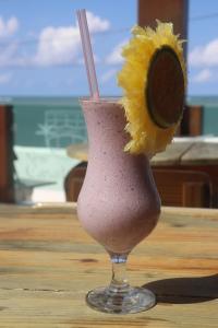 a drink in a glass with a flower on a table at New Casablanca Praia Hotel in Paulista