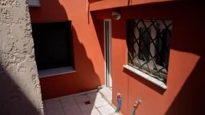 a building with a red wall with a window at Σπιτι στο κέντρο της πόλης in Mytilini