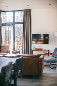 a living room with a couch and a large window at Holiday Home Maridu Family L-Cube in Arnhem
