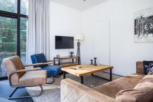 a living room with a couch and chairs and a table at Holiday Home Maridu Family L-Cube in Arnhem