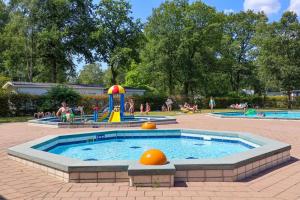 a pool in a park with people playing in it at Holiday Home Maridu Family L-Cube in Arnhem