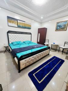 a bedroom with a bed and a blue rug at Mini Studio Calme Propre et Discrète in Dakar