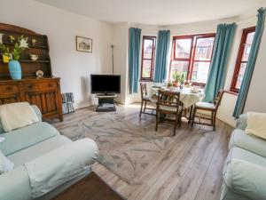 a living room with a table and a tv at Flat 9 in Swanage