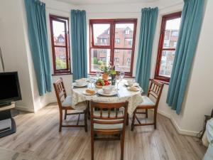 a dining room with a table and chairs and windows at Flat 9 in Swanage
