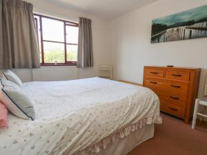 a bedroom with a bed and a dresser and a window at Flat 9 in Swanage
