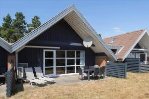 a house with chairs and a table on a patio at 0273-Romo-Lyngvejen-63-B in Rømø Kirkeby