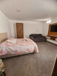 a bedroom with a bed and a couch at MP flat CDA in Araxá