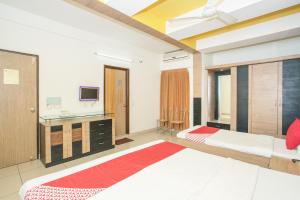 バンガロールにあるHotel O ABHIMAANI COMFORTSのベッドルーム(ベッド2台、テレビ付)