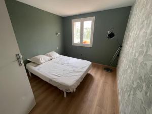 Ένα ή περισσότερα κρεβάτια σε δωμάτιο στο Logement au cœur de St Lyphard