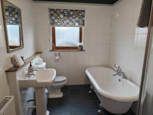 ein Badezimmer mit Waschbecken, Badewanne und Toilette in der Unterkunft Sleepy Cottage in Aviemore