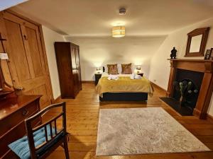 ein großes Schlafzimmer mit einem Bett und einem Kamin in der Unterkunft Sleepy Cottage in Aviemore