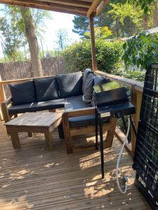 a couch on a deck with a table and a grill at Mobil Home 6 personnes La Marina in Canet-en-Roussillon +21 photos