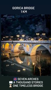 a stone bridge over a river at night at Guest House Xhaferaj in Berat +10 photos