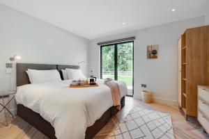 a bedroom with a large bed and a large window at Daisys Barn in Mattishall