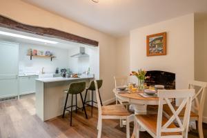 une cuisine et une salle à manger avec une table et des chaises dans l'établissement Stone Cottage, à Aylsham 16 autres photos