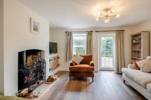 un salon avec une cheminée et un canapé dans l'établissement Stone Cottage, à Aylsham