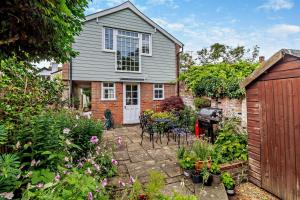 une maison avec un jardin doté d'une table et de chaises dans l'établissement Coach House Cottage Annexe, à Wickham Market