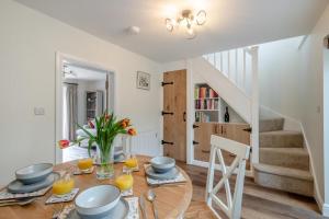 une salle à manger avec une table et un escalier dans l'établissement Stone Cottage, à Aylsham