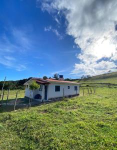 a small white house in the middle of a field at Espaço Encantado STL in São Thomé das Letras