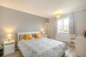 - une chambre avec un lit et 2 oreillers jaunes dans l'établissement Cornfield Bungalow, à Haddiscoe