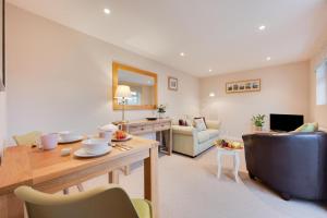 a living room with a table and a couch at Larksfield Snug in Debach +12 photos