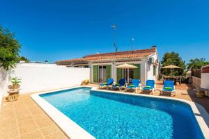 ein Swimmingpool mit Stühlen und ein Haus in der Unterkunft Villa De La Luz by Villa Plus in Punta Prima