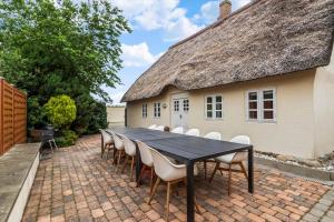 une table et des chaises noires devant une maison dans l'établissement 0499-Romo-Vestergade-29, à Sønderby