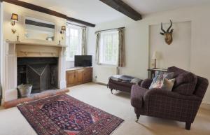 a living room with a couch and a fireplace at Mill Cottage in Ufford