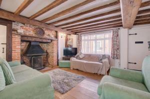 ein Wohnzimmer mit Couch und Kamin in der Unterkunft Smugglers Cottage in Southwold