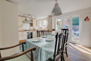 eine Küche mit einem Tisch mit einer Tischdecke darauf in der Unterkunft Smugglers Cottage in Southwold
