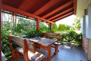 a wooden table and benches on a patio at Pas Edgarą 2 in Nida