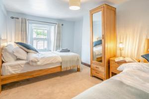 a bedroom with two beds and a mirror at 2 Bed in Defynnog oc-t32724 in Sennybridge