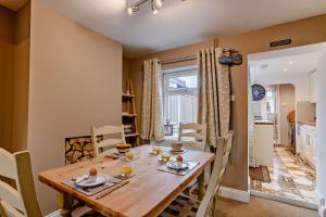 a dining room with a wooden table and chairs at Paddington Cottage - Dersingham in Dersingham +15 photos
