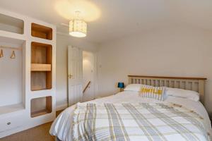 a bedroom with a bed with a striped blanket at Paddington Cottage - Dersingham in Dersingham