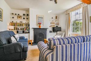 ein Wohnzimmer mit zwei Sofas und einem Kamin in der Unterkunft Dart Cottage in Aldeburgh
