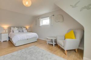 a bedroom with a bed and a chair and a window at Fallowfield in Reydon
