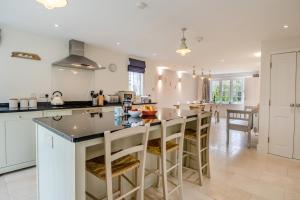 a kitchen with a large island with bar stools at Pembroke Cottage in Walberswick