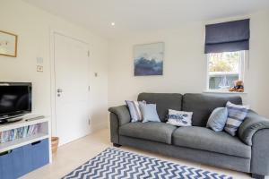 a living room with a couch and a tv at Pembroke Cottage in Walberswick