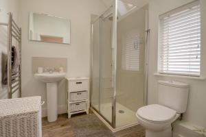 a bathroom with a toilet and a sink and a shower at Pembroke Cottage in Walberswick +17 photos