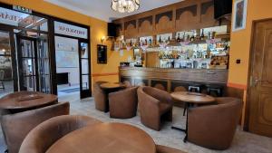 a restaurant with tables and chairs and a bar at Hotel Orchidea in Balástya