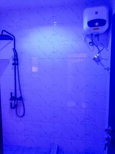a bathroom with a shower and a soap dispenser on a wall at dreamland hotel in Abuja