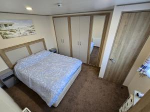 een kleine slaapkamer met een bed en een deur bij 2 Bed Caravan With Decking in Saint Osyth +14 foto's