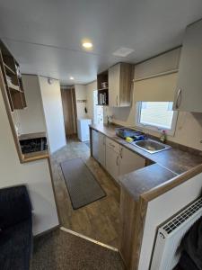een kleine keuken met een spoelbak en een aanrechtblad bij 2 Bed Caravan With Decking in Saint Osyth