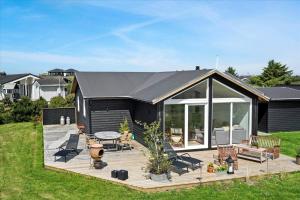 a black house with a deck with a table and chairs at 0035-Romo-Lakolk-39 in Lakolk